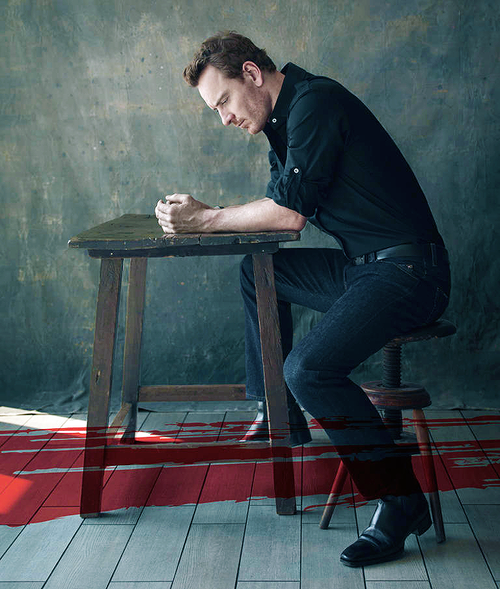 Man At Wooden Table Portrait Dimly Lit Room