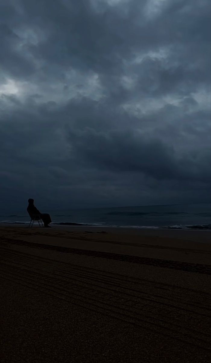 Lone Figure Overlooking Stormy Seaside Landscape