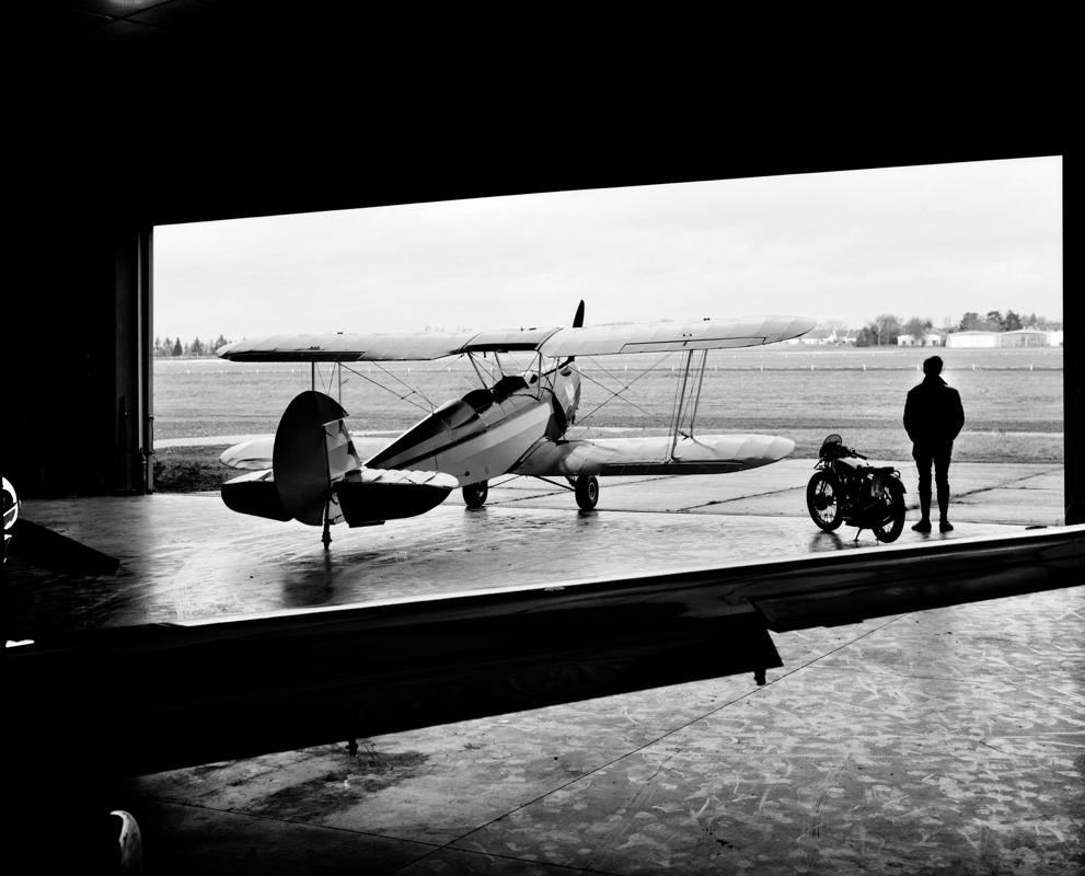 Vintage Biplane And Solitary Figure Airfield Landscape