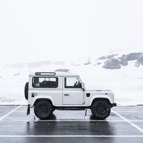 Off-road Land Rover In Snowy Mountains Landscape