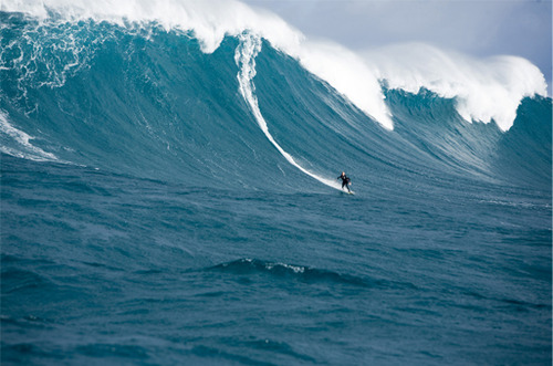 Surfer Riding Colossal Ocean Wave