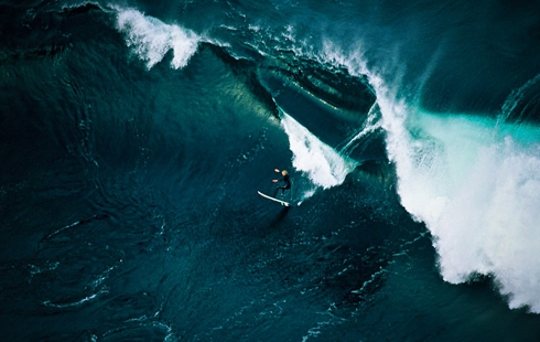 Surfer Riding Towering Ocean Waves