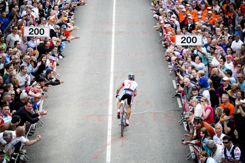 Cyclist Racing Through Crowd Landscape