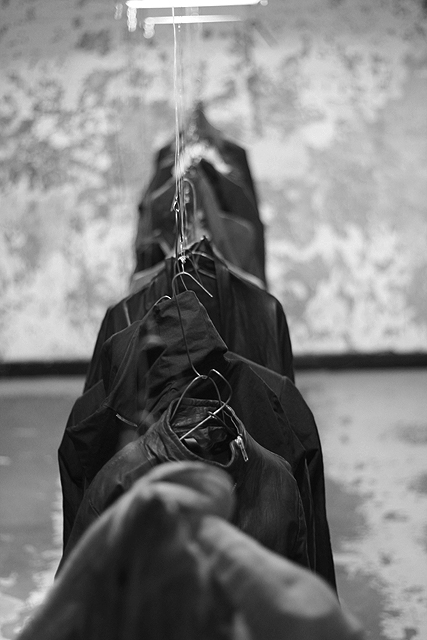 Hooded Figure In Dimly Lit Chamber