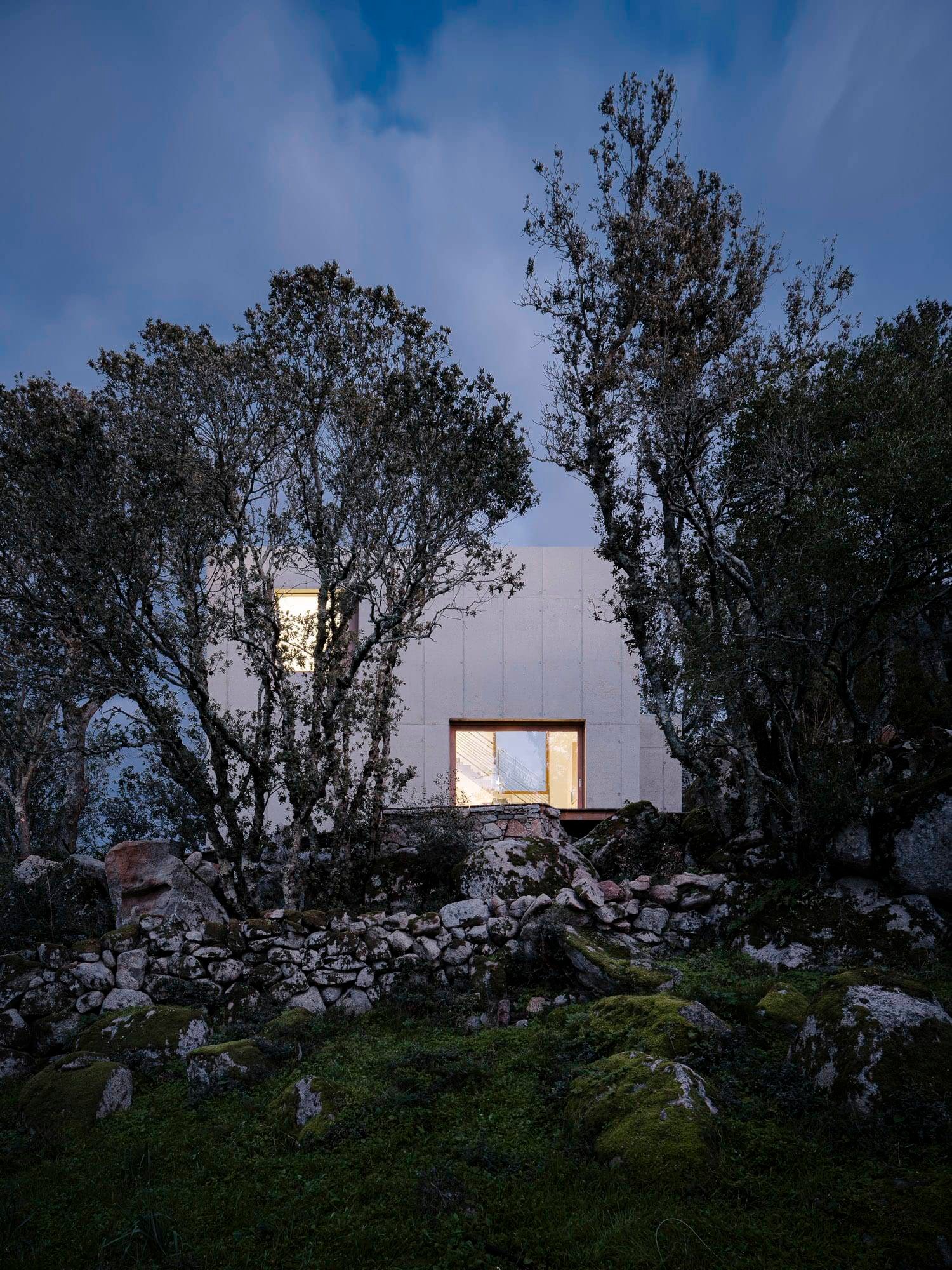Modern White Concrete House Among Trees Rocky Hillside Dusk