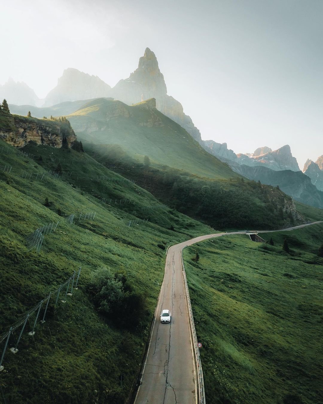 White Car Driving Mountain Road Green Hills Misty Peaks