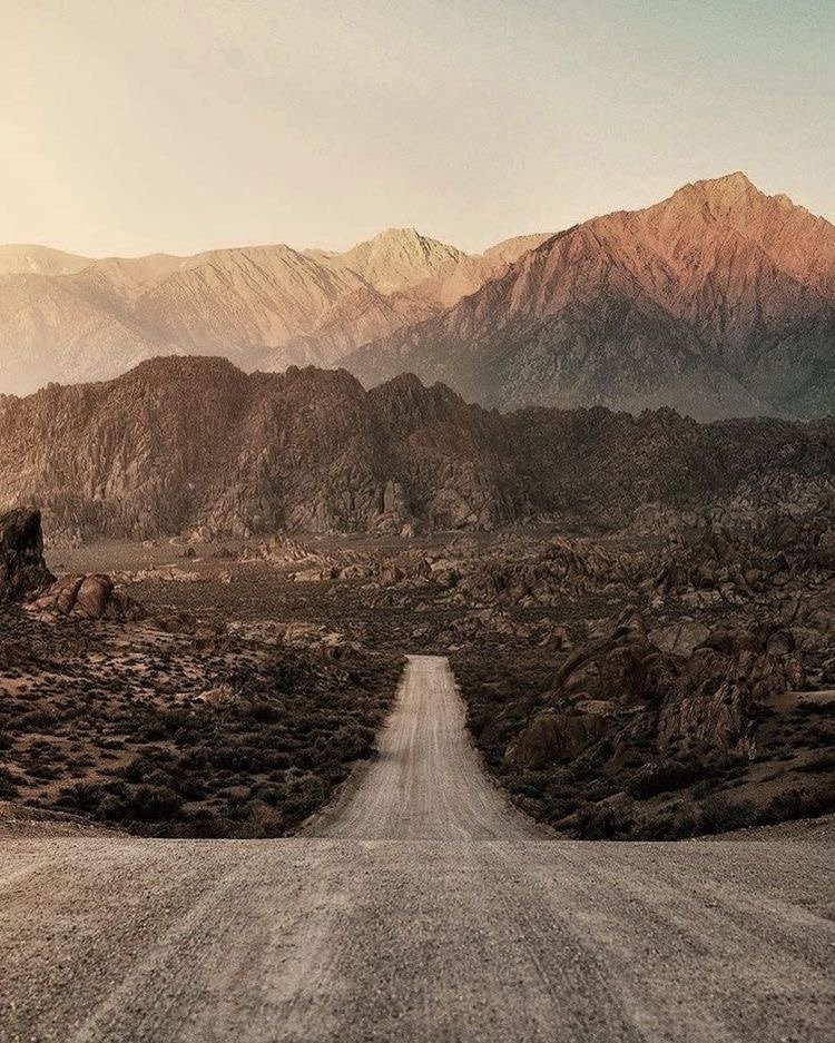 Desert Dirt Road Leading To Rocky Mountains Sunset