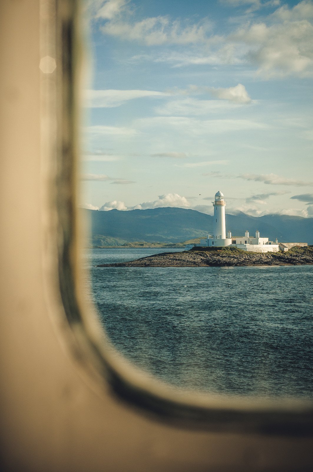 White Lighthouse Mountain View Through Boat Window Scotland Coast
